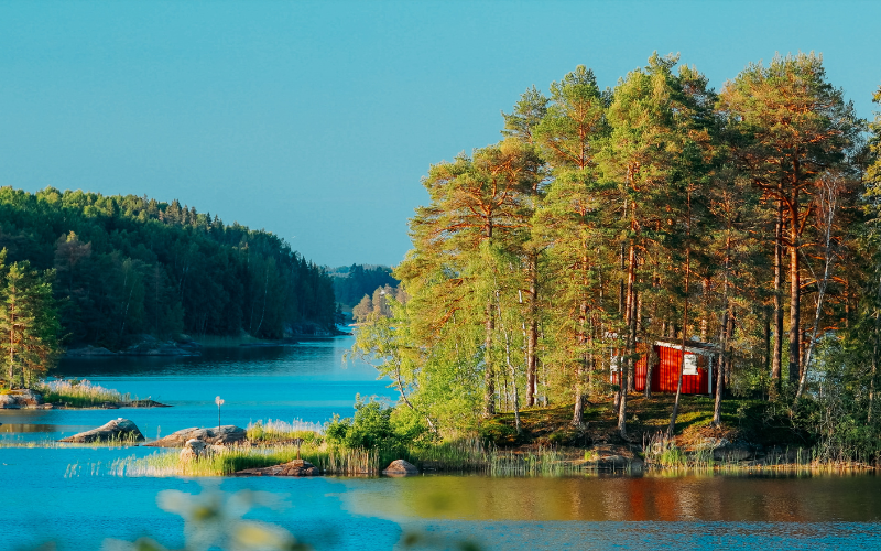 View of a Swedish river with a red cabin in the trees